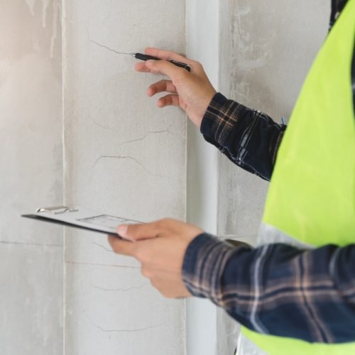 Asian,Inspector,Checking,Structure,Of,New,Property,And,Taking,Note