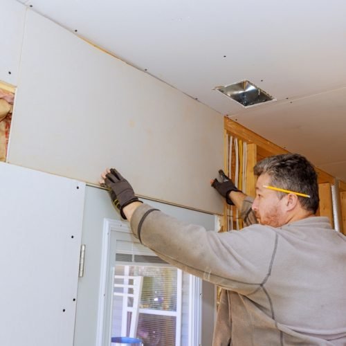 Carpenter,Is,Carefully,Placing,Drywall,Sheetrock,Sheets,On,Interior,Wall